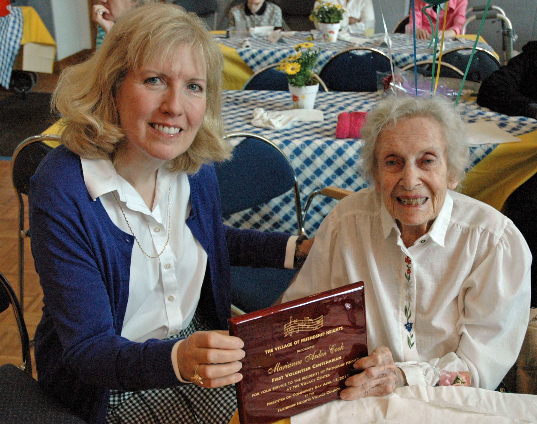 First Volunteer Centenarian Marianne Arden Cook is shown with her plaque honoring her dedication to Friendship Heights Village.